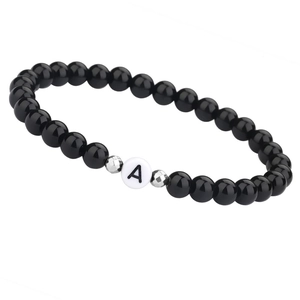 Gepolijste zwarte onyx kralenarmband met witte letter A kraal en zilveren tussenstukjes