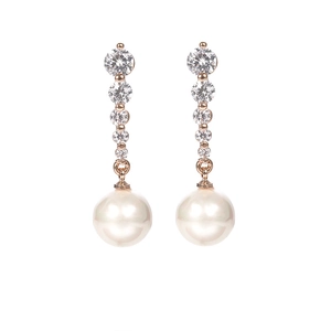 Detalle de pendientes de perlas de oro rosa con pedrería sobre fondo blanco