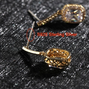 Detalle del sello S925 de plata de ley en pendientes dorados con circonitas y pavé