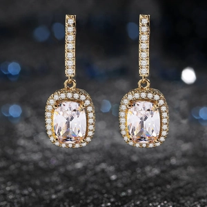 Vista macro detallada de pendientes de aro dorados con circonita de corte cojín y pavé de joyas