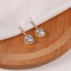 Detalle de pendientes de oro con circón rectangular y engaste de micro-pavimento