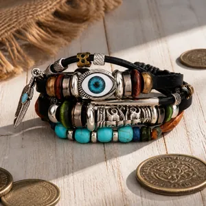 Détail d'un bracelet bohème multicouche avec perles mauvais œil et pendentif en plume