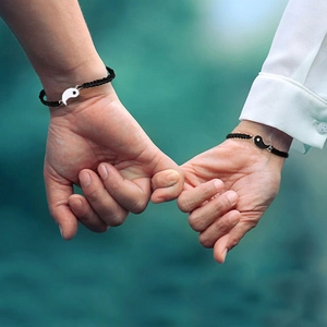 Nahaufnahme der verstellbaren Yin Yang geflochtenen Partnerarmbänder für Paare