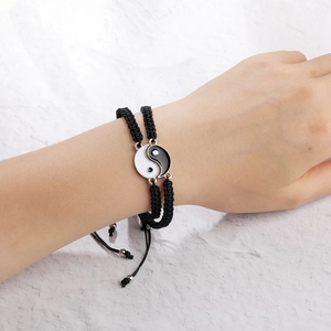 Detail von verstellbaren Paar-Armbändern mit schwarz-weißen Tai Chi Yin Yang-Anhängern