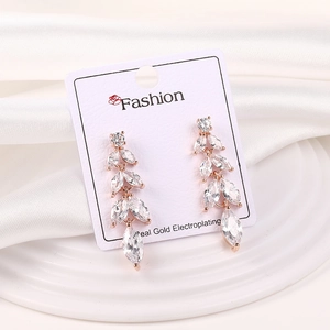 Detalle de pendientes de oro rosa con circonitas marquesa en un diseño de hojas