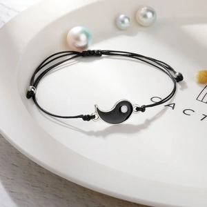 Detail des handgewebten schwarzen Kordelarmbands mit silbernem Tai Chi Yin Yang Anhänger