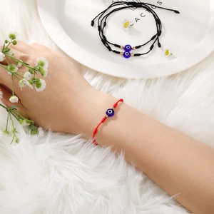 Detail van handgemaakte boze oog armbanden in rood en zwart met verstelbaar trekkoord