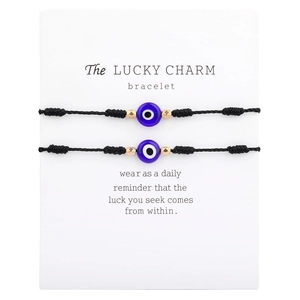 Macro-opname van verstelbare Evil Eye-armbanden met zwart koord en blauwe glazen kralen