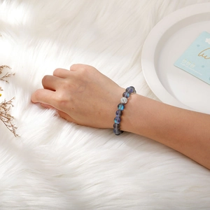 Detail of frosted moonlight bead bracelet with a crystal-studded charm on a wrist