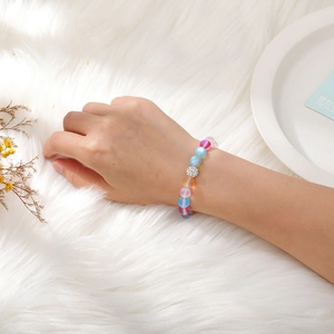 Close-up of colorful matte beaded elastic bracelet with a sparkling rhinestone ball charm