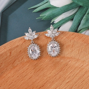 Detalle de pendientes de plata con circonitas ovaladas y diseño de hoja floral