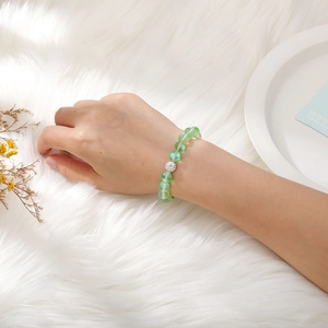 Detail of beaded stretch bracelet with green gemstones and silver micro-set diamond bead