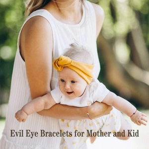 Detailed view of red woven Evil Eye bracelets for mother and child on a wrist