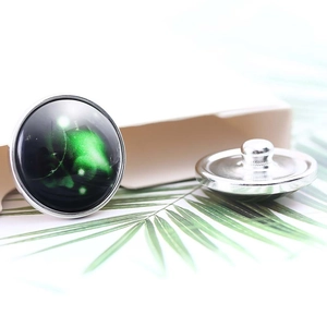 Macro view of 20mm silver constellation buttons with green nebula art glass cabochons