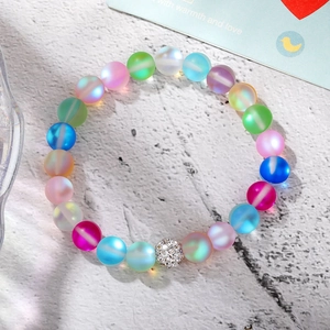 Detailed macro view of colorful frosted beads bracelet with a pavé crystal ball charm