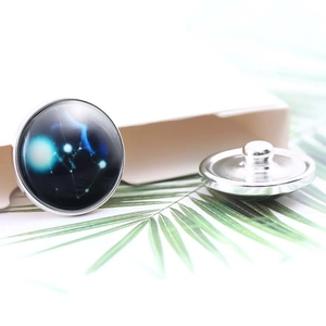 Detail of 20mm silver constellation buttons featuring deep blue nebula patterns on a white gift box