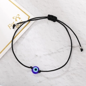Detail of handmade black woven Evil Eye bracelet with adjustable knot and gift card