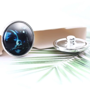 Detailed macro view of 20mm glass snap button with celestial blue constellation pattern