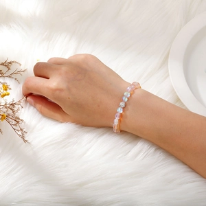 Close-up of frosted moonstone beaded bracelet with sparkling rhinestone clay bead on wrist