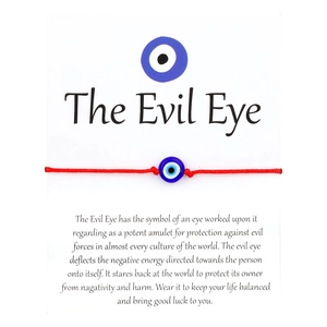 Red braided cord bracelet with Evil Eye bead on English instructional display card