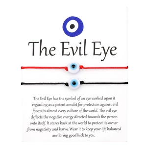 Detail of red and black braided Evil Eye bracelets with blue bead on display card