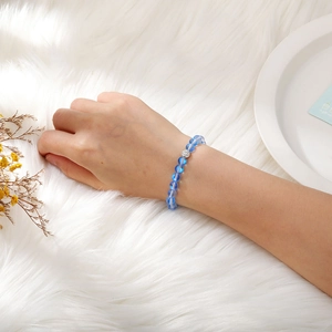 Close-up of translucent blue beaded elastic bracelet with silver pavé bead on a wrist