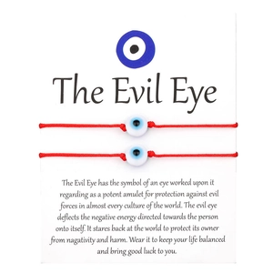 Detail of red Evil Eye woven bracelets set on premium gift display card packaging