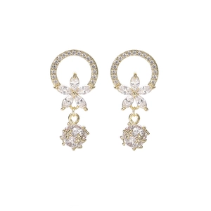 Detalle de pendientes dorados de circón con flor de cristal y colgante redondo brillante