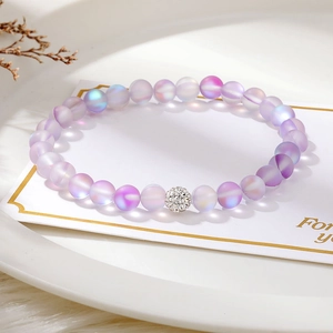 Detail of gradient frosted beaded bracelet with crystal pavé ball on a white tray