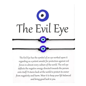Detail of adjustable woven Evil Eye friendship bracelets on white descriptive card