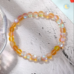 Close-up of orange moonstone beaded elastic bracelet with a sparkling silver crystal ball bead