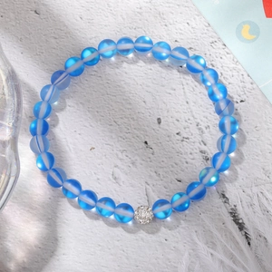Detailed macro view of a blue frosted moonstone elastic bracelet with a silver micro-pave ball