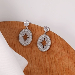 Vista macro de pendientes de plata con diamantes pavé y patrón de estrella central