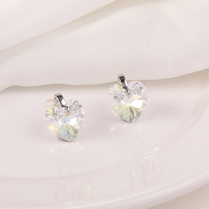Vista detallada de pendientes de cristal en forma de corazón con lazo de plata y diamantes