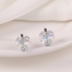 Detalle de pendientes de cristal irisado en forma de corazón con diseño de lazo