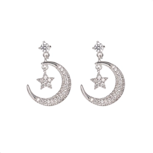 Detalle de pendientes de plata con estrella y luna e incrustaciones de circonita
