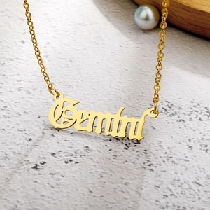 Polished gold Gemini zodiac pendant necklace in elegant cursive script on a delicate chain