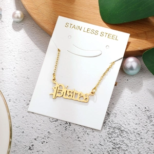 Golden Pisces zodiac letter pendant in stainless steel on white jewelry card