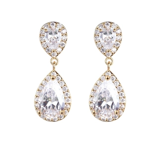 Detalle macro de pendientes de gota dorados con brillantes circonitas engastadas