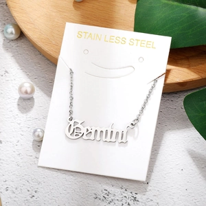 Detail of Gemini constellation pendant in silver stainless steel on product packaging