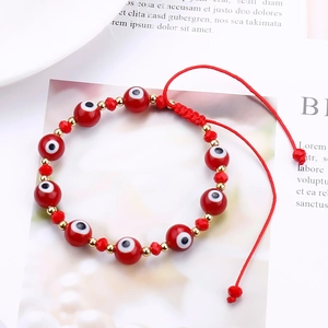 Macro detail of red Evil Eye beaded bracelet with adjustable red woven rope cord