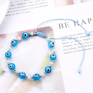 Detail of blue evil eye beaded bracelet with faceted beads and adjustable woven cord
