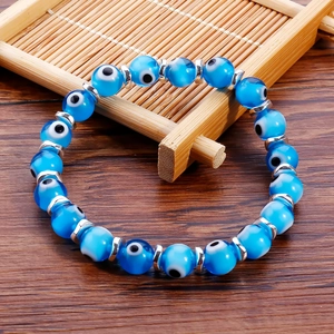 Macro detail of blue evil eye beads with silver spacers on a handmade beaded bracelet