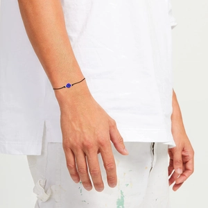 Dettaglio del braccialetto Evil Eye intrecciato nero con perla blu e accenti argentati