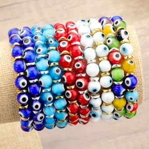 Handmade evil eye bead bracelet set with metallic spacers on a rustic display