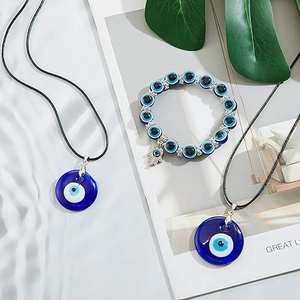 Flat lay of Evil Eye jewelry set with blue glass pendants and beaded hand charm bracelet