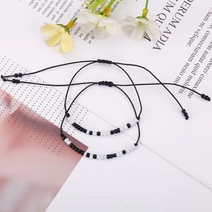 Detailed view of Morse Code woven bracelets with black and white beads for couples
