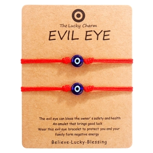 Detail der roten gewebten Evil-Eye-Armbänder auf einer Kraftpapierkarte für Paare