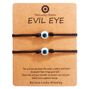 Paar verstellbare schwarze Evil Eye Armbänder auf Kraftkarton für Glück und Schutz