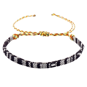 Detail van een bohemien geweven armband met geometrische patronen en kleurrijke koorden